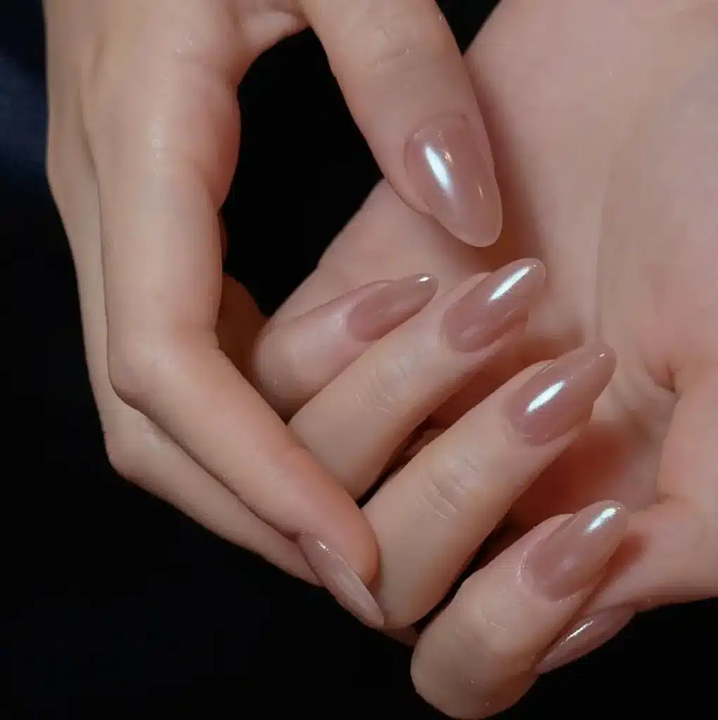 Unhas com esmalte rosé gold e brilho delicado.