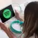 Pessoa utilizando tablet com o logo do Spotify enquanto prepara fones de ouvido, representando a divulgação dos álbuns mais ouvidos de 2025.