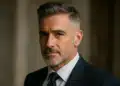 Homem de terno com expressão confiante e corte de cabelo Taper Fade