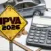 Placa amarela escrita IPVA 2026, ao lado de calculadora, moedas e carro em miniatura.