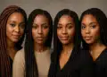 Quatro mulheres negras com tranças posando lado a lado