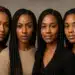 Quatro mulheres negras com tranças posando lado a lado