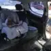 Cadeirinha de bebê instalada no banco traseiro de um carro, com assento acolchoado e cinto de segurança visível.