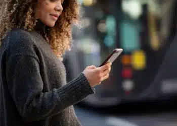 Pessoa usando um celular para transferir dados de um celular antigo para um novo.