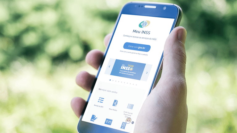Pessoa segurando celular com o app Meu INSS, que está temporariamente indisponível durante modernização do sistema.