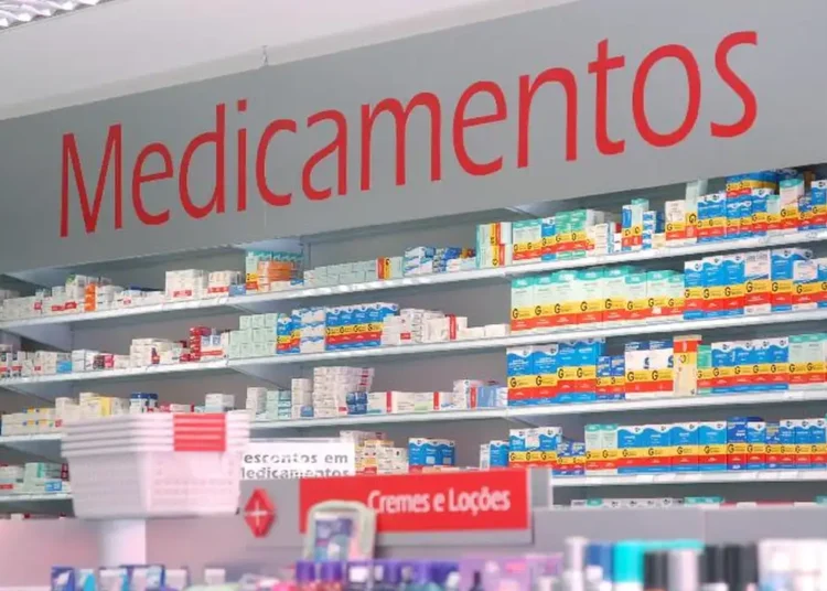 Prateleiras organizadas com caixas de medicamentos em farmácia, com destaque para a placa "Medicamentos".