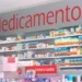 Prateleiras organizadas com caixas de medicamentos em farmácia, com destaque para a placa "Medicamentos".