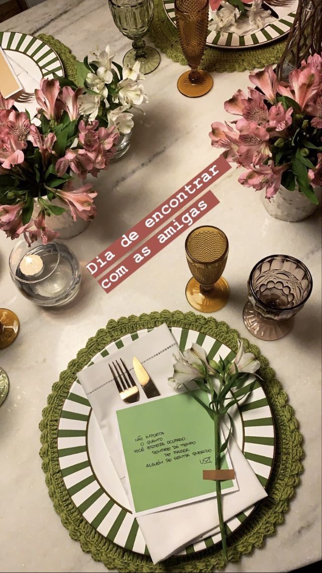 Mesa decorada com flores, pratos verdes, taças e cartão, encontro de amigas