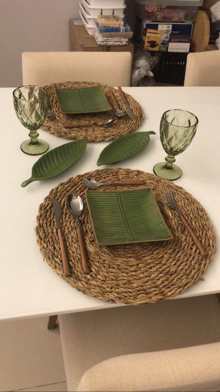 Mesa posta com sousplats de fibra natural e louça verde folha em ambiente informal