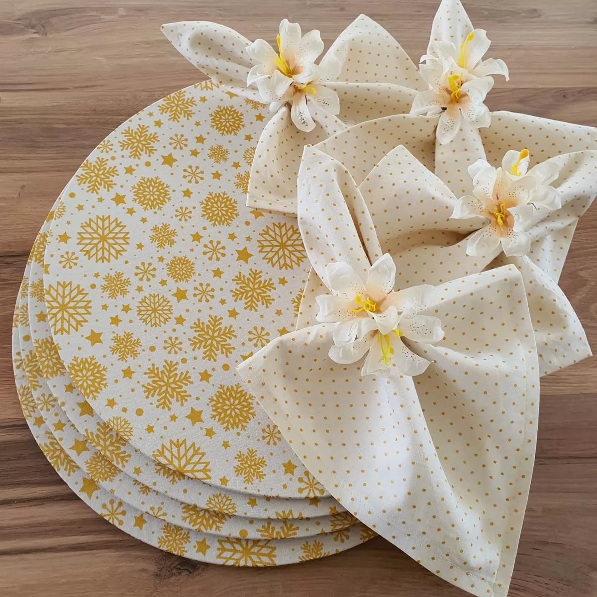 Conjunto de sousplats e guardanapos brancos com detalhes dourados e flores artificiais