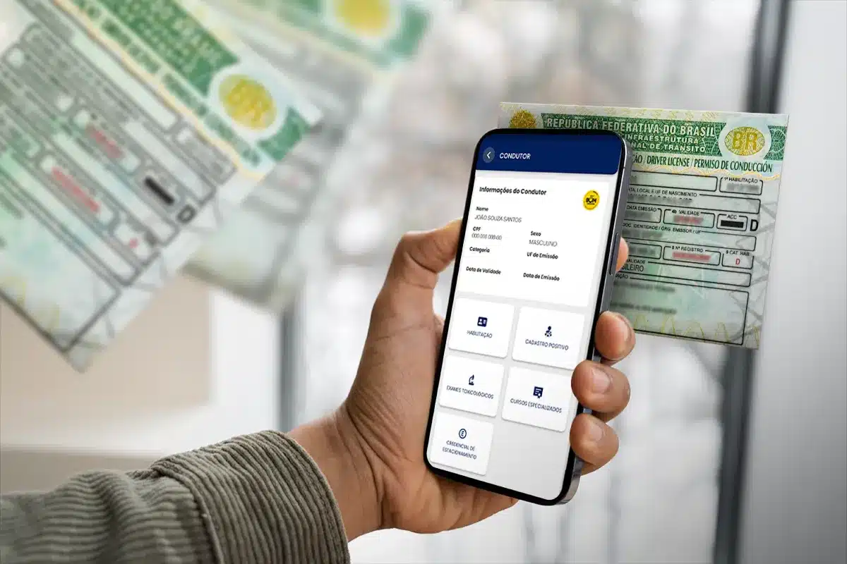  Mão segura celular com login em app da CNH, documento físico ao fundo
