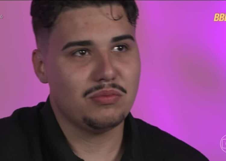 Close do rosto de Pedro, participante do BBB 26, com expressão séria e pensativa, em frente a um fundo rosa vibrante com os logotipos oficiais do programa no canto superior e inferior direito.