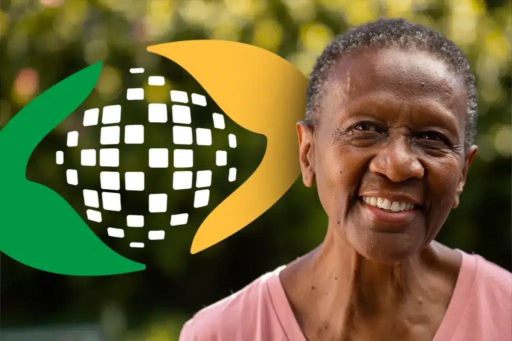Mulher idosa negra, sorridente, com cabelos curtos e grisalhos. Ao fundo, o logotipo estilizado do INSS em cores verde e amarelo aparece de forma suave e desfocada.