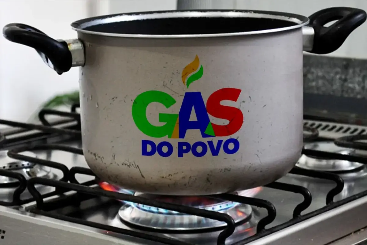 Panela sobre fogão aceso com logomarca do programa Gás do Povo destacada. 