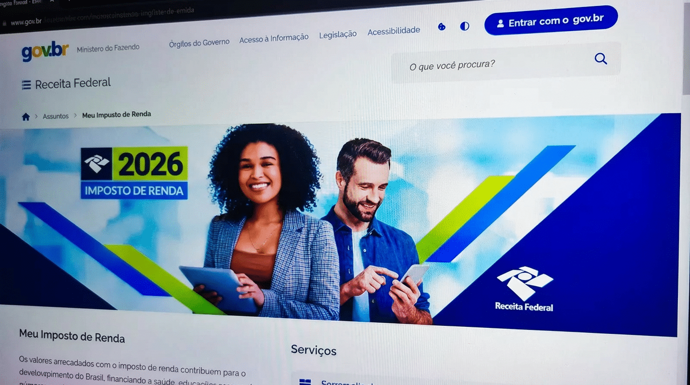 Duas pessoas acessando tablets e sorrindo diante de tela da Receita Federal com banner do Imposto de Renda 2026