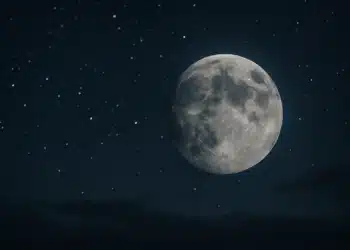 Lua cheia brilhando em céu escuro repleto de estrelas, transmite calma e serenidade