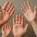 Quatro mãos de diferentes tamanhos levantadas