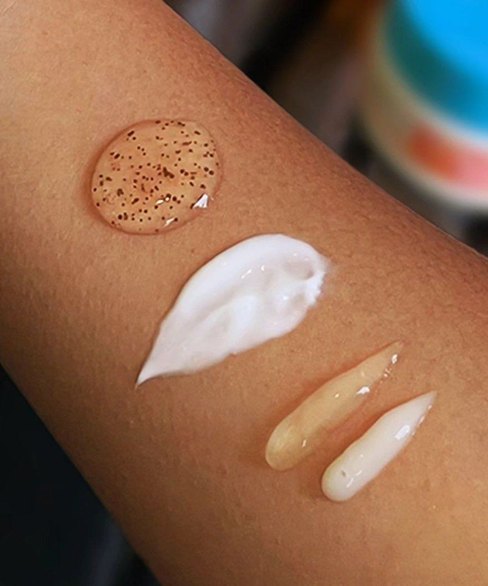 Diferentes texturas de cremes e géis aplicadas em fileiras sobre o braço