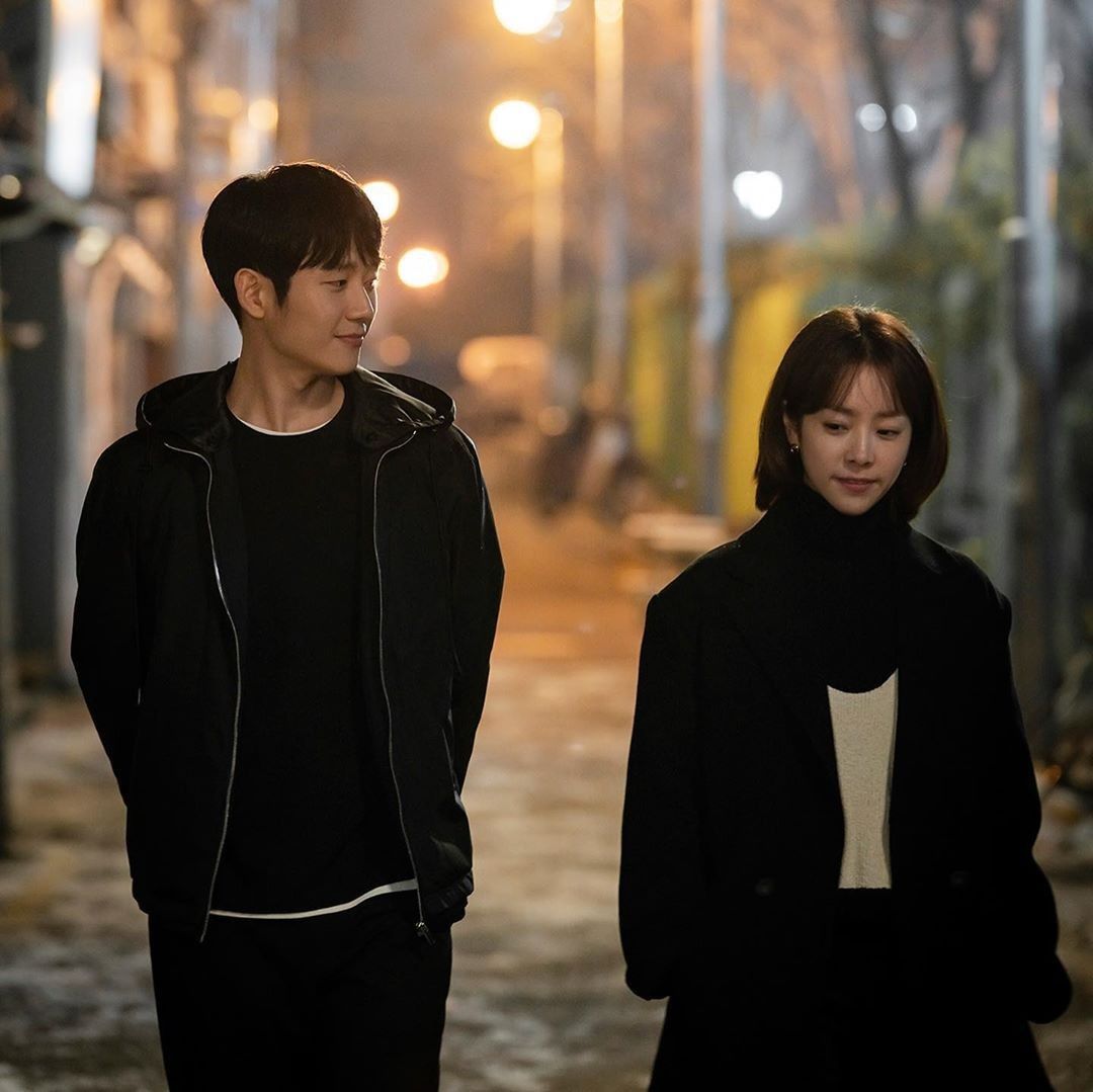 Homem e mulher andando lado a lado em rua iluminada à noite, clima de romance