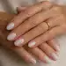 Mãos femininas maduras exibindo unhas soap nails claras e anel dourado