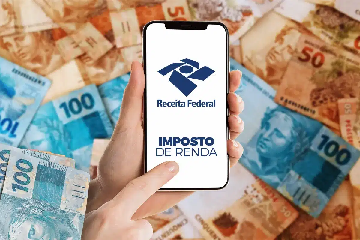 Mãos segurando celular com logotipo da Receita Federal e notas de R$ 100 e R$ 50 ao fundo