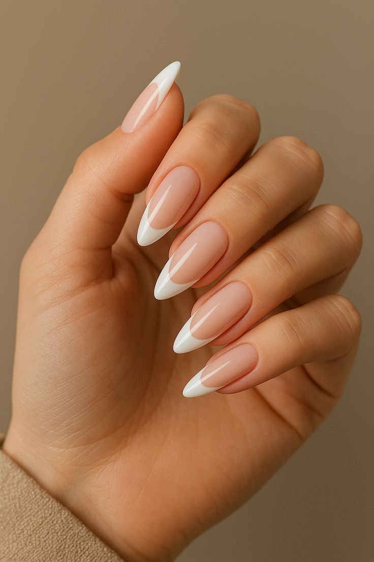 Mão com unhas longas amendoado, esmalte nude e francesinha branca moderna