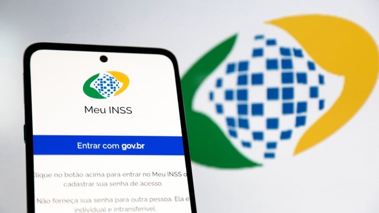 Tela de celular exibe login do Meu INSS com logotipo destacado ao fundo desfocado