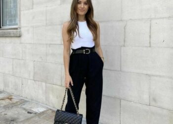 Mulher usando calça preta, blusa branca, mule preto e bolsa elegante na rua