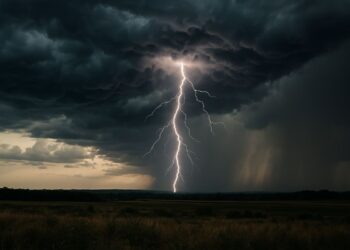 Raio caindo sobre campo aberto com nuvens escuras e chuva intensa ao fundo