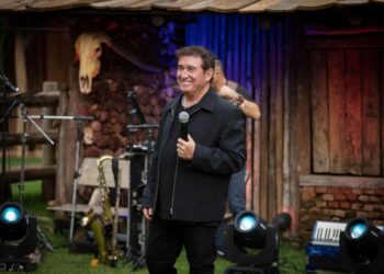 Amado Batista durante apresentação com microfone no palco