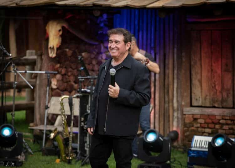 Amado Batista durante apresentação com microfone no palco