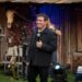 Amado Batista durante apresentação com microfone no palco