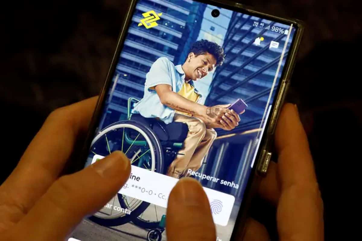 Mãos segurando celular com aplicativo do BB aberto