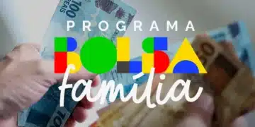 Pessoa recebendo notas de real em mãos, representando pagamento do Bolsa Família
