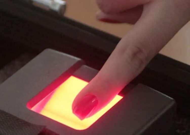 Pessoa realizando leitura biométrica digital em dispositivo eletrônico