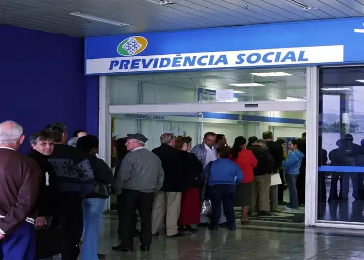 Fila de pessoas em agência da previdência social aguardando atendimento