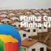 Conjunto habitacional com casas brancas e telhados de cerâmica com logo do programa