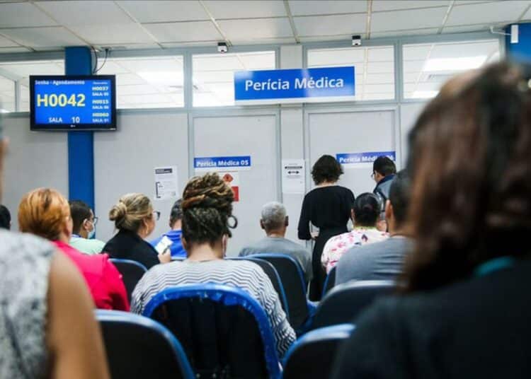 Sala de espera da Perícia Médica do INSS com beneficiários aguardando atendimento