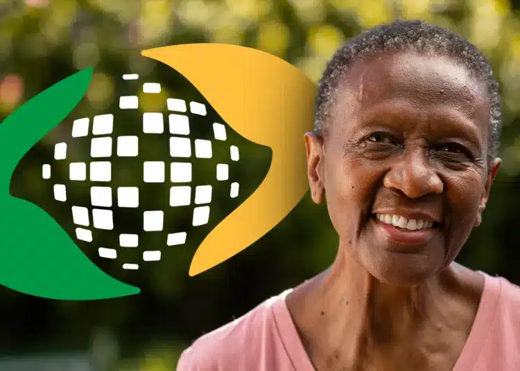 Mulher idosa sorridente em primeiro plano, com o logotipo estilizado do INSS (mãos em verde e amarelo envolvendo um globo) ao fundo, representando a segurança e o atendimento ao beneficiário.