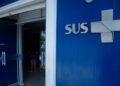 Fachada de unidade de saúde com logo do sus na parede azul