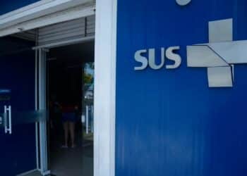 Fachada de unidade de saúde com logo do sus na parede azul