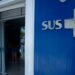 Fachada de unidade de saúde com logo do sus na parede azul