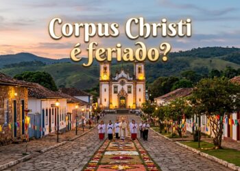 Sacerdotes caminham sobre tapete floral na rua de pedras, com Igreja Matriz de Santo Antônio ao fundo em Tiradentes, MG