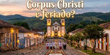 Sacerdotes caminham sobre tapete floral na rua de pedras, com Igreja Matriz de Santo Antônio ao fundo em Tiradentes, MG