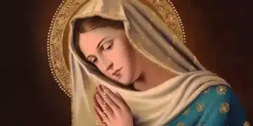 Pintura devocional de Nossa Senhora com mãos postas, véu branco com bordas douradas, manto azul turquesa bordado e auréola de pérolas douradas