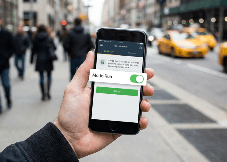 Mão segurando smartphone com app bancário mostrando botão Modo Rua ativado e botão verde Ativar, em rua movimentada com táxis