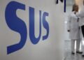 Sigla SUS em azul em destaque numa parede