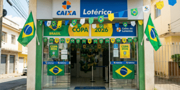 Fachada de lotérica CAIXA com bandeiras do Brasil, bandeirolas e cartazes Copa 2026 nas cores verde e amarela