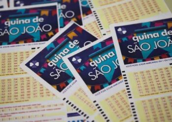 Volantes temáticos da Quina de São João empilhados, exibindo bandeirinhas coloridas e grade numérica para apostas