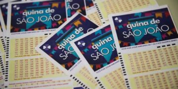 Volantes temáticos da Quina de São João empilhados, exibindo bandeirinhas coloridas e grade numérica para apostas